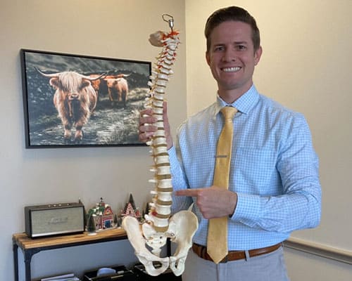 Dr. Dillan holding spine structure and pointing at disks